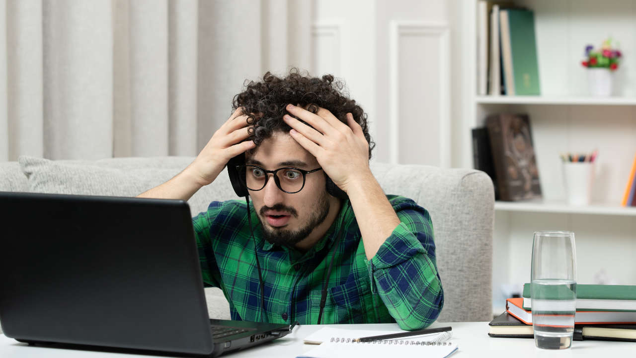 Jovem no notebook com cara de preocupado sem saber o que acontece se não pagar o FIES