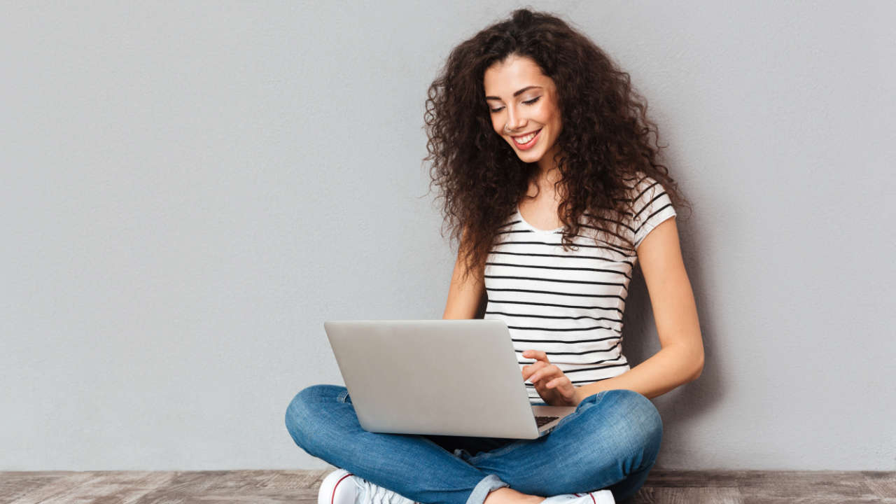 Mulher jovem usando notebook para ver simulador Fies 2025