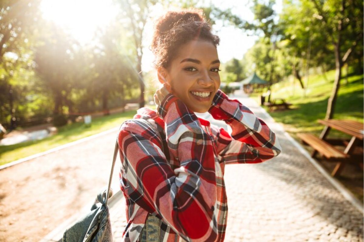 Uma menina sorrindo enquanto anda pela universidade