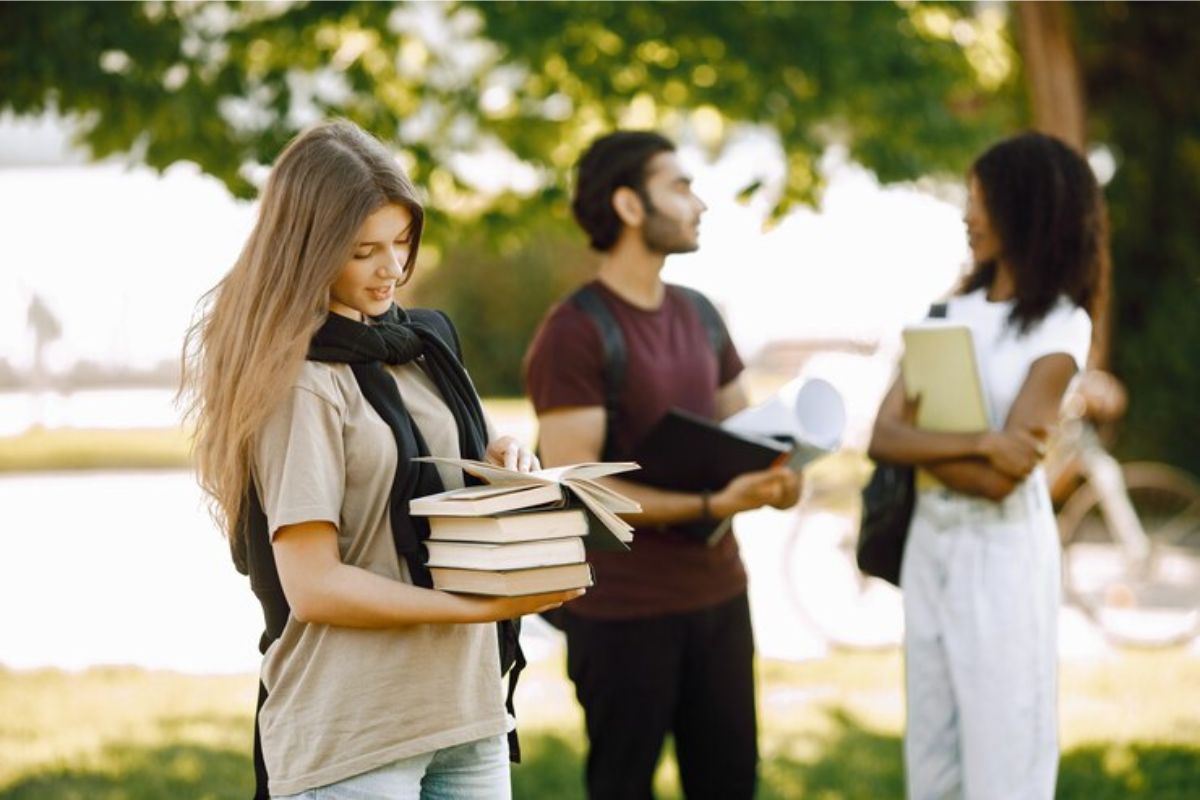 Três estudantes no jardim da universidade conversam sobre o Novo FIES UDF 2025