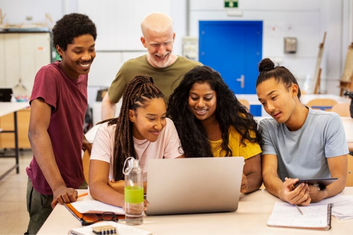 alunos em sala de aula olhando para um notebook